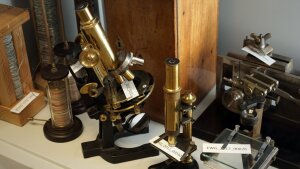 Historical equipment such as microscopes and charge columns from the 19th century