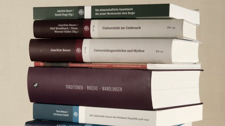 Photograph of a stack of books on the subject of university history
